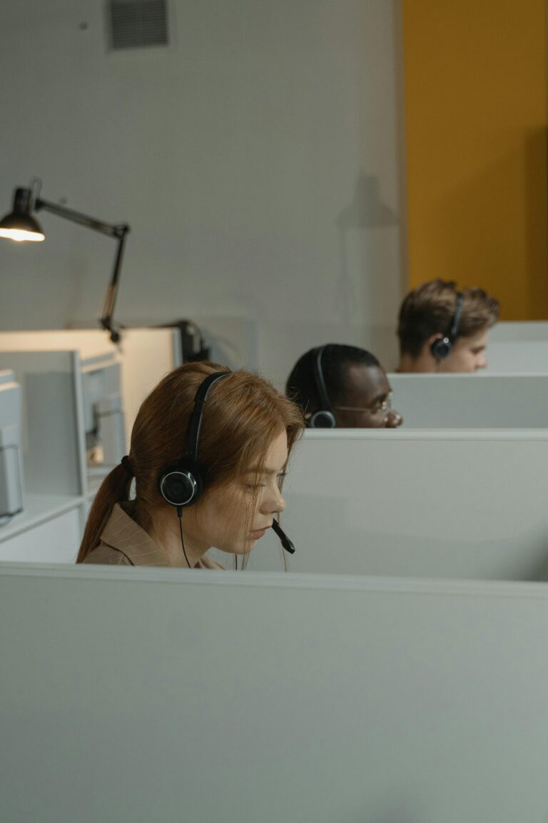 Diverse call center agents focused on their tasks in a modern workspace with headsets.